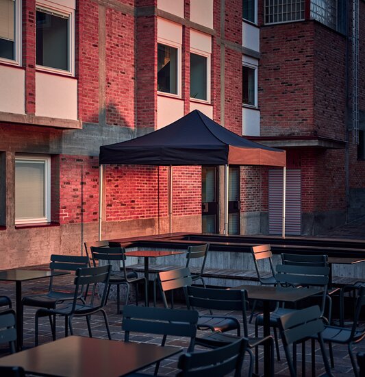 Der schwarze 3x3 m Faltpavillon dient als Outdoor-Überdachung auf der Terrasse.